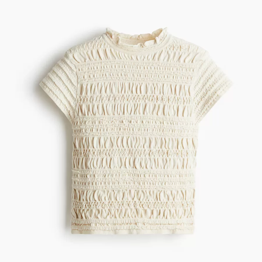 Κοντή, εφαρμοστή μπλούζα με μαλακή τρυπητή πλέξη, σφηκοφωλιά, στρογγυλή ριμπ λαιμόκοψη με βολανάκι και κοντό μανίκι.